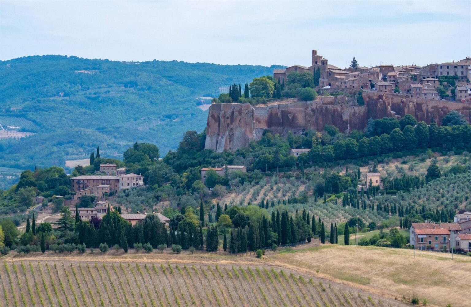 Borgo medievale su rupe di tufo circondato da uliveti, cipressi e vigneti tra le colline dell'Italia centrale